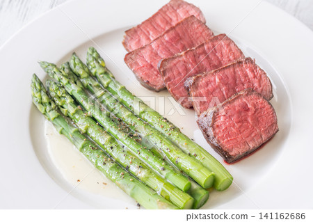 Juicy Medium Rare Steak Served With Asparagus And Lemon Butter Sauce Elegantly Juicy Medium Rare Steak Served With Asparagus And Lemon Butter Sauce Elegantly 141162686