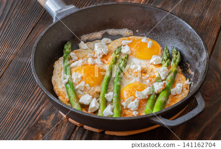 Rustic Breakfast Skillet With Fried Eggs Asparagus And Feta Cheese 141162704