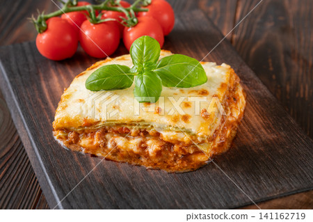 Traditional Lasagna Bolognese Slice Served On Dark Rustic Wooden Board Traditional Lasagna Bolognese Slice Served On Dark Rustic Wooden Board 141162719
