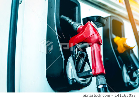 Petrol pump filling fuel nozzle in gas station. Fuel dispenser machine. Refuel fill up with petrol gasoline. Petrol industry and service. Red petrol fuel nozzle. Petroleum oil industry. Oil crisis. Petrol pump filling fuel nozzle in gas station. Fuel dispenser machine. Refuel fill up with petrol gasoline. Petrol industry and service. Red petrol fuel nozzle. Petroleum oil industry. Oil crisis. 141163052