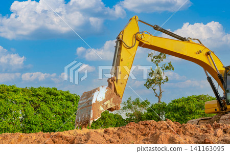 Backhoe working by digging soil at construction site. Bucket of backhoe are digging soil. Crawler excavator digging on soil. Excavating machine. Earth moving machine. Excavation vehicle. Backhoe working by digging soil at construction site. Bucket of backhoe are digging soil. Crawler excavator digging on soil. Excavating machine. Earth moving machine. Excavation vehicle. 141163095