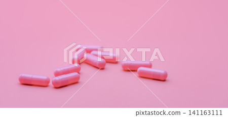 Pink capsule pills on pink background. Pharmaceutical industry. Health and medicine. Pharmacy banner. Pills of love. Treatment and care for love. Online pharmacy background. Vitamins and supplements. Pink capsule pills on pink background. Pharmaceutical industry. Health and medicine. Pharmacy banner. Pills of love. Treatment and care for love. Online pharmacy background. Vitamins and supplements. 141163111