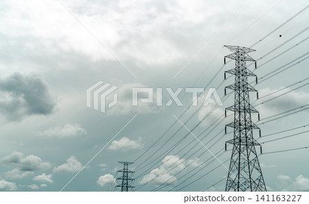 High voltage electric pylon and electrical wire with grey sky and white clouds. Electricity poles. Power and energy concept. High voltage grid tower with wire cable. Infrastructure. Power distribution High voltage electric pylon and electrical wire with grey sky and white clouds. Electricity poles. Power and energy concept. High voltage grid tower with wire cable. Infrastructure. Power distribution 141163227