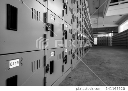 Perspective view of locker with lock and numbered white tags at locker room. Locker for safety and security storage. Row of lockers with locked door background. Hallway in locker room. Perspective view of locker with lock and numbered white tags at locker room. Locker for safety and security storage. Row of lockers with locked door background. Hallway in locker room. 141163620