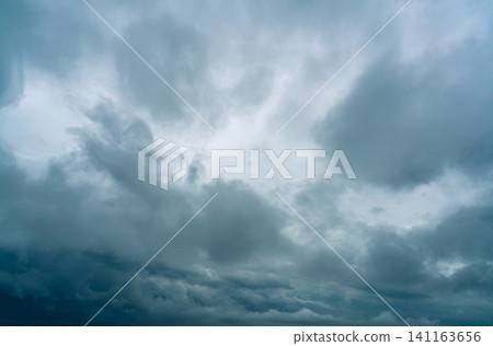 Dark dramatic sky and clouds. Background for death and sad concept. Gray sky and fluffy white clouds. Thunder and storm sky. Sad and moody sky. Nature background. Dead abstract background. Cloudscape. 141163656