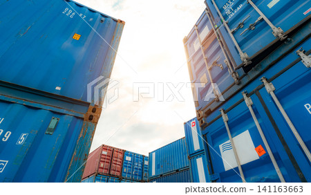 Blue and red logistic container against white sky. Cargo and shipping business. Container ship for import and export logistics. Logistic industry. Container for truck transport and air logistic. Blue and red logistic container against white sky. Cargo and shipping business. Container ship for import and export logistics. Logistic industry. Container for truck transport and air logistic. 141163663