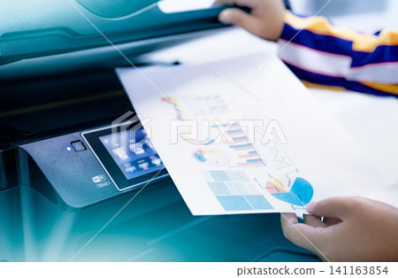 Office worker print paper on multifunction laser printer. Copy, print, scan, and fax machine in office. Modern print technology. Photocopy machine. Document and paper work. Scanner. Secretary work. Office worker print paper on multifunction laser printer. Copy, print, scan, and fax machine in office. Modern print technology. Photocopy machine. Document and paper work. Scanner. Secretary work. 141163854