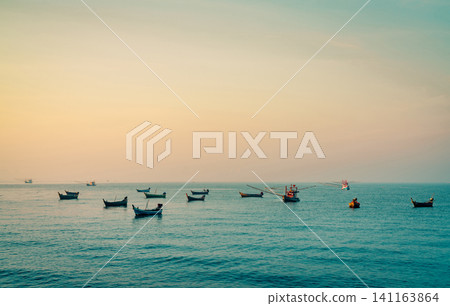 Fishing boat with beautiful sunset sky. Fishing boat anchored at Koh Kood, Thailand at dusk. Calm and peaceful concept. Stunning sunset sky. Romantic seascape. Summer vacation. Thailand travel. 141163864