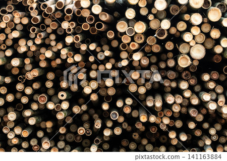 Pile of bamboo pole. Stack of round timber logs. Large batch of wooden logs for industrial scale or manufacturing. Warehouse of material for furniture factory. Art of bamboo abstract background. Pile of bamboo pole. Stack of round timber logs. Large batch of wooden logs for industrial scale or manufacturing. Warehouse of material for furniture factory. Art of bamboo abstract background. 141163884
