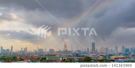 Cityscape of modern building with highway and community in Bangkok. Skyscraper building. Urban skyline. Cityscape with a rainbow on the stormy sky and sunlight. Storm clouds above the city. Cityscape of modern building with highway and community in Bangkok. Skyscraper building. Urban skyline. Cityscape with a rainbow on the stormy sky and sunlight. Storm clouds above the city. 141163909