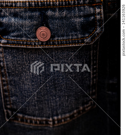 Selective focus on denim jean jacket pocket in clothes shop. Denim jacket pocket and button texture. Textile industry. Jeans fashion and shopping concept. Clothing concept. Denim jacket for sale. 141163926
