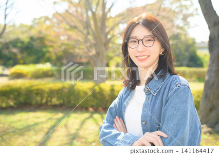 Japanese woman wearing glasses in a park Japanese woman wearing glasses in a park 141164417