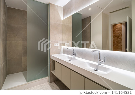 Modern bathroom interior with double sinks sleek faucets and glass shower in neutral tones and contemporary design, with bathroom, interior, modern, contemporary detail Modern bathroom interior with double sinks sleek faucets and glass shower in neutral tones and contemporary design, with bathroom, interior, modern, contemporary detail 141164521