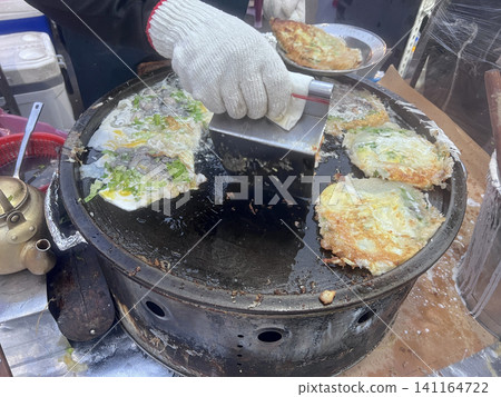 在台中的夜市拍攝攤販熟練地製作蚵仔煎 在台中的夜市拍攝攤販熟練地製作蚵仔煎 141164722
