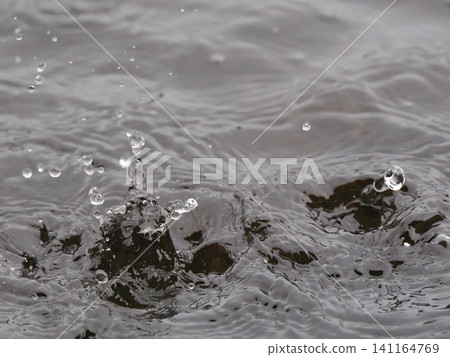 Water drops falling on the water surface Water drops falling on the water surface 141164769