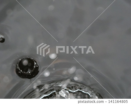 Water drops falling on the water surface Water drops falling on the water surface 141164805