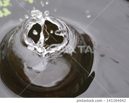 Water drops falling on the water surface Water drops falling on the water surface 141164842