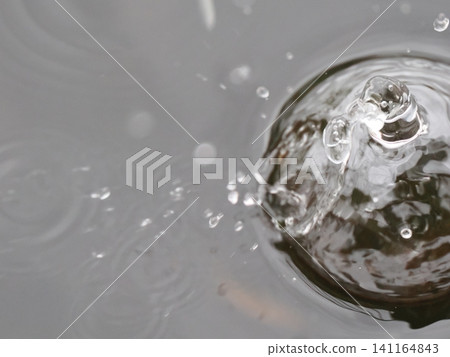 Water drops falling on the water surface Water drops falling on the water surface 141164843