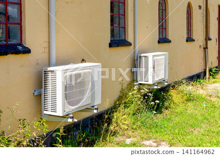 Outdoor heat pump units installed on building wall Outdoor heat pump units installed on building wall 141164962