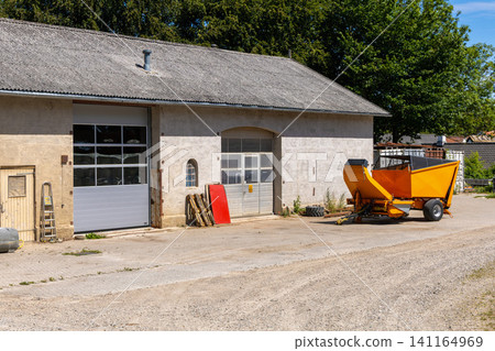 Farm machinery beside agricultural building in Denmark Farm machinery beside agricultural building in Denmark 141164969