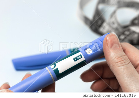Hand holding Ozempic injection pen for diabetes treatment. Hand holding Ozempic injection pen for diabetes treatment. 141165019