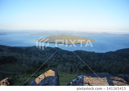 A spectacular view of Lake Kussharo and Nakajima Island from Bihoro Pass, seen over the rocky cliffs. A spectacular view of Lake Kussharo and Nakajima Island from Bihoro Pass, seen over the rocky cliffs. 141165415