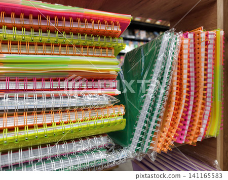 Brightly colored spiral notebooks with soft covers organized neatly in school supplies shop Brightly colored spiral notebooks with soft covers organized neatly in school supplies shop 141165583