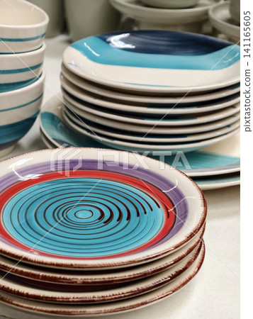 Plates on shelves in store, closeup of ceramic dishware for kitchen and household Plates on shelves in store, closeup of ceramic dishware for kitchen and household 141165605