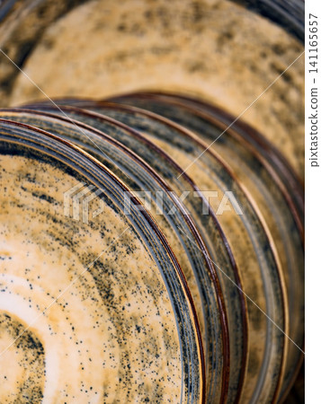 Yellow plates on shelves in store, close up of ceramic dishware for kitchen and household 141165657