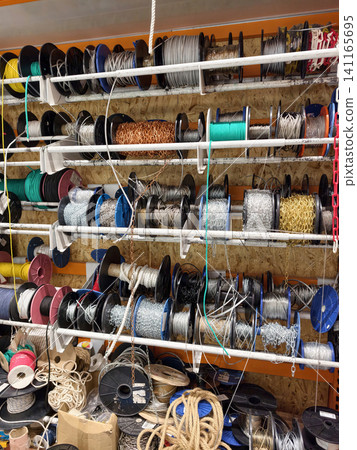 Metal ropes cables and chains coiled and stored in bobbins inside a building supply store highlighting essential equipment for securing and lifting Metal ropes cables and chains coiled and stored in bobbins inside a building supply store highlighting essential equipment for securing and lifting 141165695