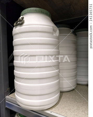 Big white plastic drums arranged neatly on shelves in a hardware store for customers Big white plastic drums arranged neatly on shelves in a hardware store for customers 141165731