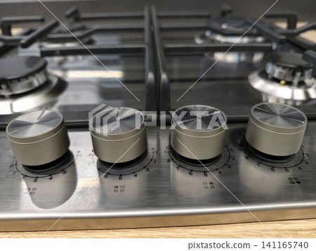 Close up of built in gas stove control knobs, metal appliance with precise adjustment for burners and oven, modern kitchen equipment for home cooking Close up of built in gas stove control knobs, metal appliance with precise adjustment for burners and oven, modern kitchen equipment for home cooking 141165740