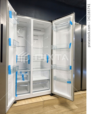 Large two-door refrigerator with open doors, perfect for organizing your groceries, available at a hypermarket Large two-door refrigerator with open doors, perfect for organizing your groceries, available at a hypermarket 141165741