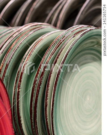Beautiful turquoise ceramic plates on shelves in supermarket, close up of ceramic tableware plates for household and kitchen use Beautiful turquoise ceramic plates on shelves in supermarket, close up of ceramic tableware plates for household and kitchen use 141165754