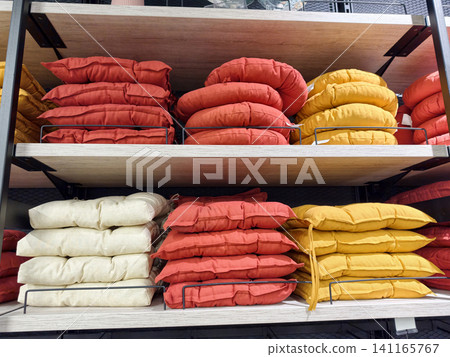Soft seat pads showcased on supermarket shelves with organized chair cushions and home textile comfort items in retail environment 141165767