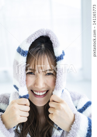 一位年輕女子興奮地穿著連帽衫。 一位年輕女子興奮地穿著連帽衫。 141165773