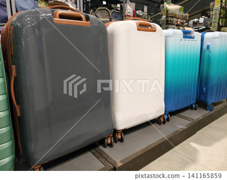 Neatly arranged dark light and blue luggage and backpacks on shop racks Neatly arranged dark light and blue luggage and backpacks on shop racks 141165859