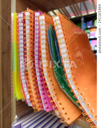Softcover notebooks with spiral binding displayed in multiple colors on stationery shelf Softcover notebooks with spiral binding displayed in multiple colors on stationery shelf 141165864