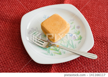 Place the square castella-style Japanese sweets on a white plate. Place the square castella-style Japanese sweets on a white plate. 141166117