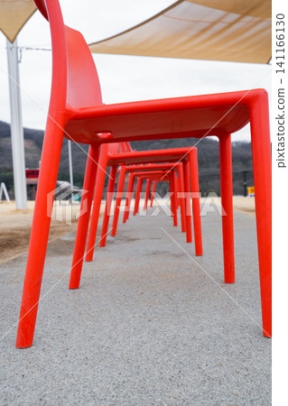 A photograph with an artistic composition of rows of red chairs. A photograph with an artistic composition of rows of red chairs. 141166130