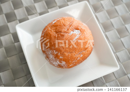 A view from above of donuts served on a white plate. 141166137