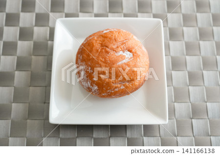 A bright, overhead photograph of donuts on a white plate. A bright, overhead photograph of donuts on a white plate. 141166138