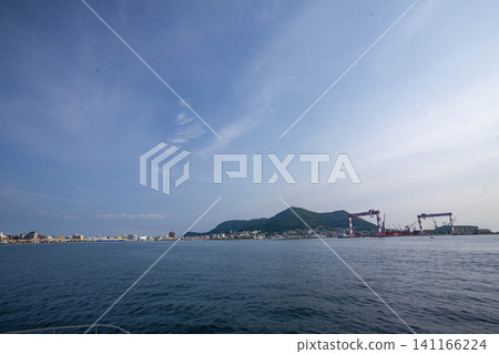 Mount Hakodate and port facilities viewed from the sea, and the Hokkaido landscape reflected in the blue ocean. Mount Hakodate and port facilities viewed from the sea, and the Hokkaido landscape reflected in the blue ocean. 141166224