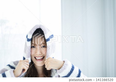 A young woman excitedly wearing a hoodie. A young woman excitedly wearing a hoodie. 141166520