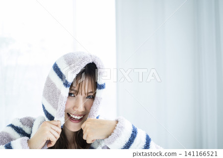 A young woman excitedly wearing a hoodie. A young woman excitedly wearing a hoodie. 141166521