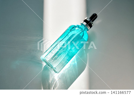Blue cosmetic serum bottle with pipette showing hydration concept Blue cosmetic serum bottle with pipette showing hydration concept 141166577