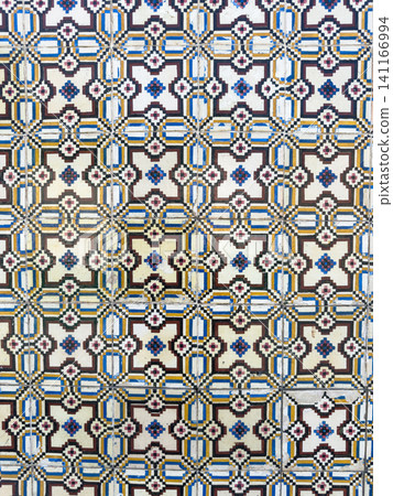 Traditional Portuguese azulejo wall tiles featuring a vibrant geometric pattern in blue yellow and black creating a historic Mediterranean aesthetic Traditional Portuguese azulejo wall tiles featuring a vibrant geometric pattern in blue yellow and black creating a historic Mediterranean aesthetic 141166994
