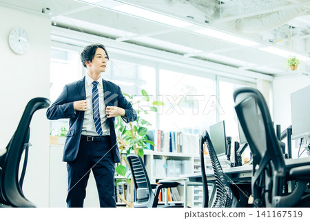 A male businessman in a suit starts running in the office. A male businessman in a suit starts running in the office. 141167519