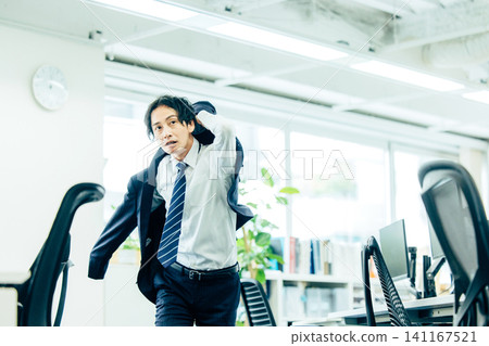 A male businessman in a suit starts running in the office. A male businessman in a suit starts running in the office. 141167521