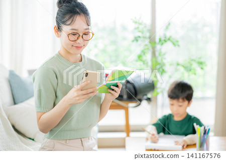 Mother looking at bankbook and smartphone in the living room Mother looking at bankbook and smartphone in the living room 141167576